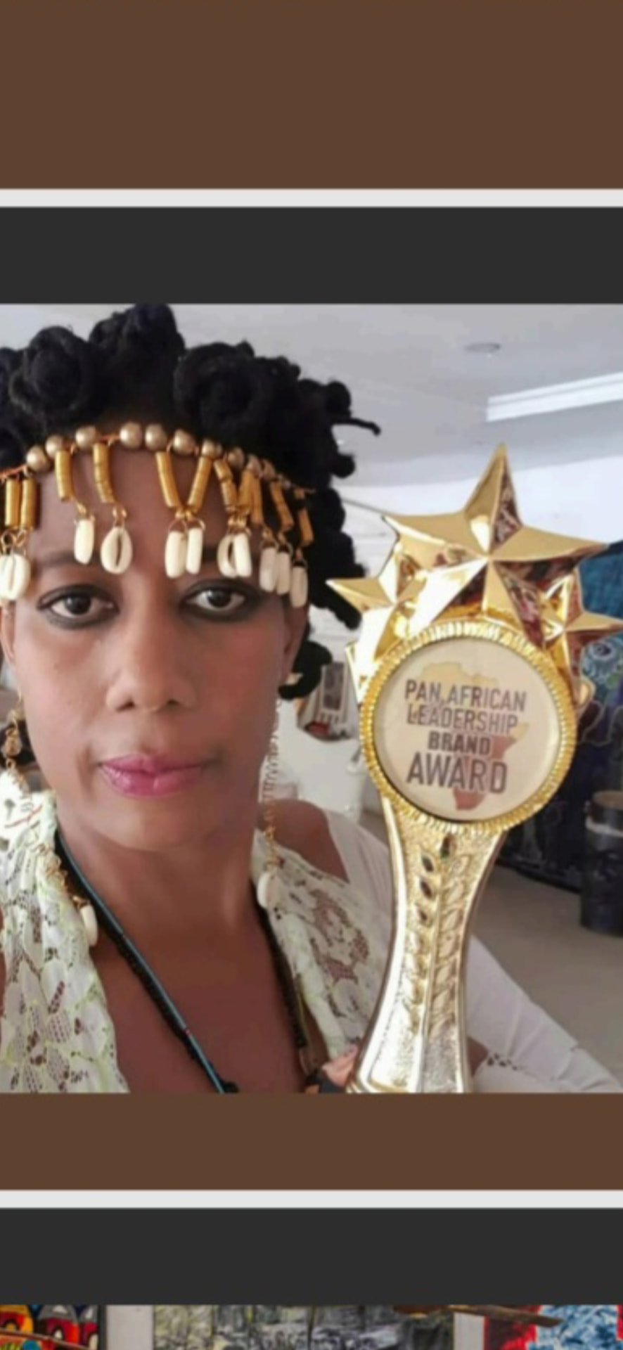 ElnanaAfrika holding her Pan African Leadership Brand Award trophy